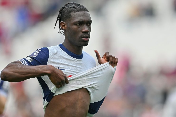 Bissouma in primo piano si alza la maglia del Tottenham